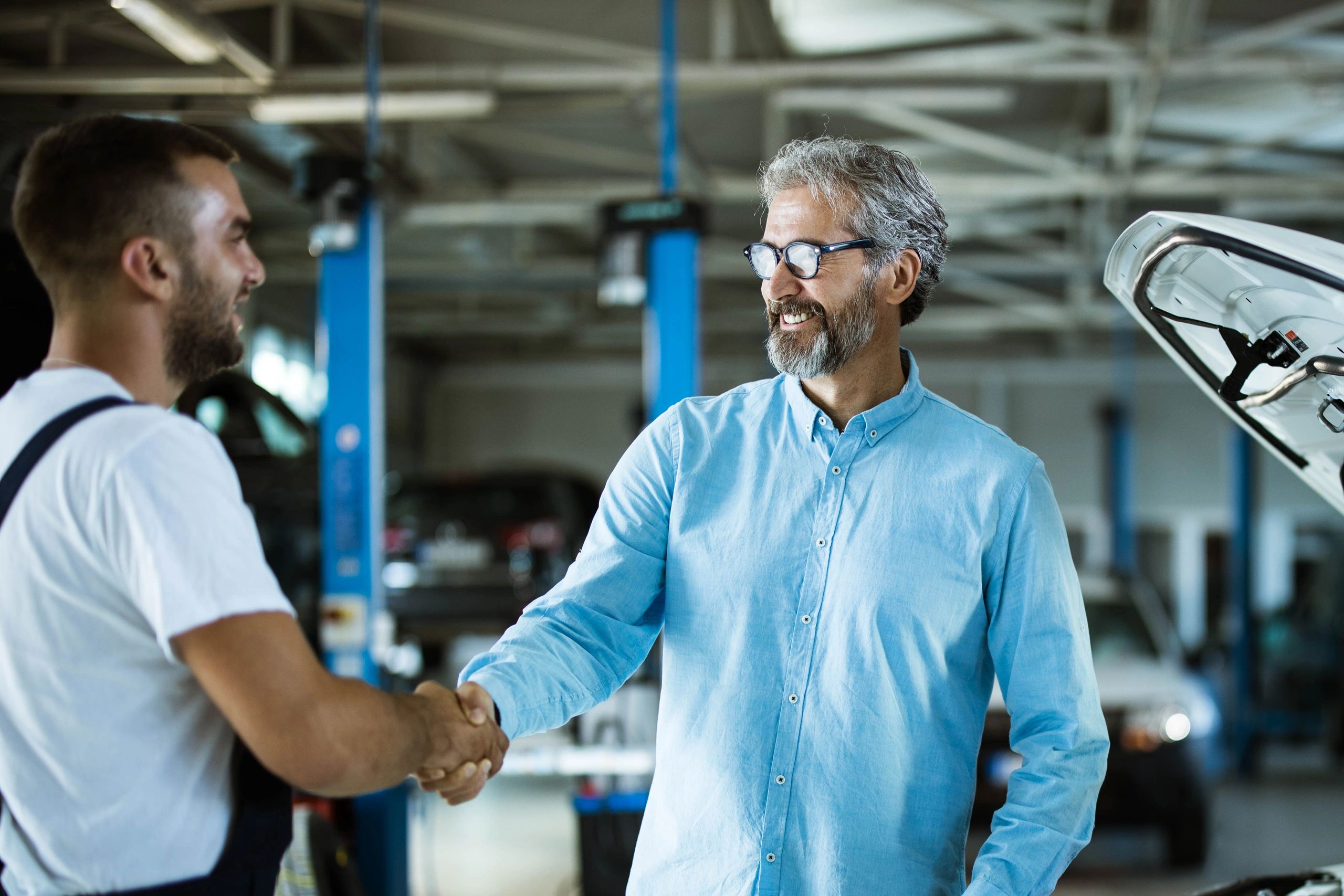 Customer shaking hands with a mechanic in an auto repair shop