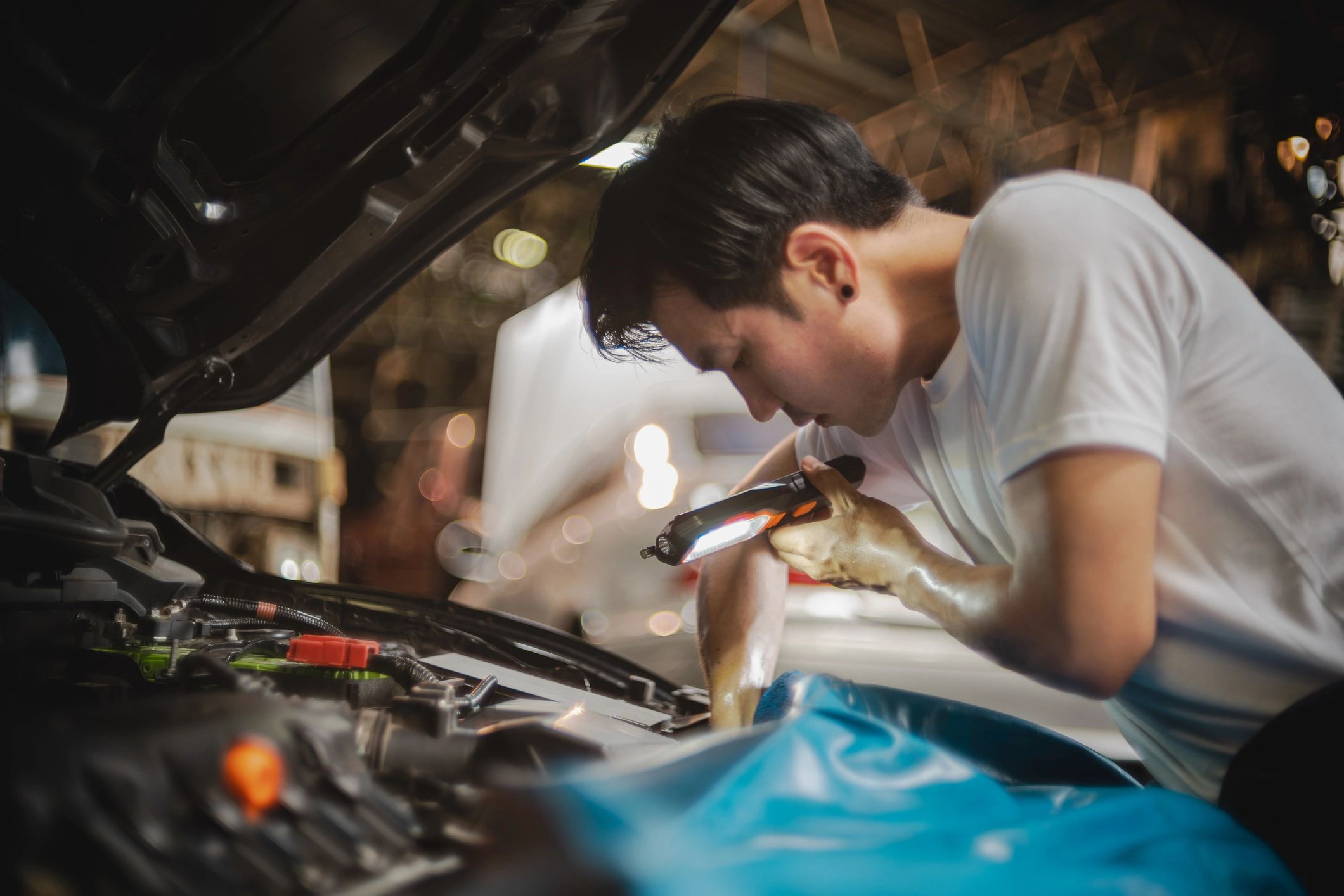 Technician inspecting a car engine bay