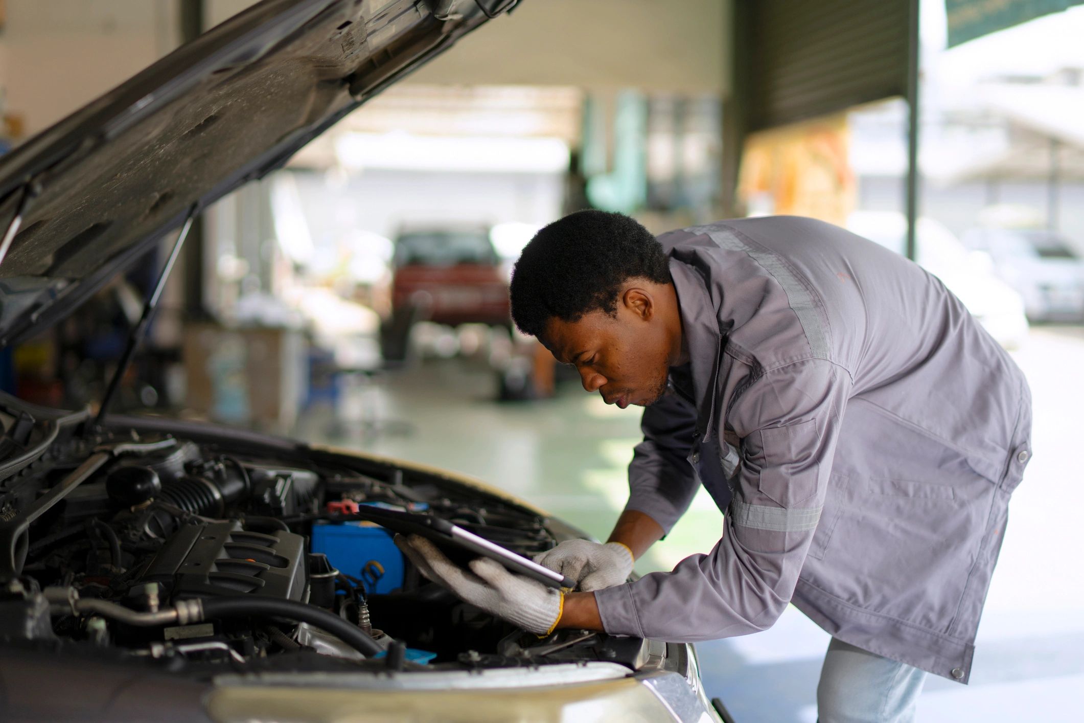 Technician working on a vehicle in a service bay