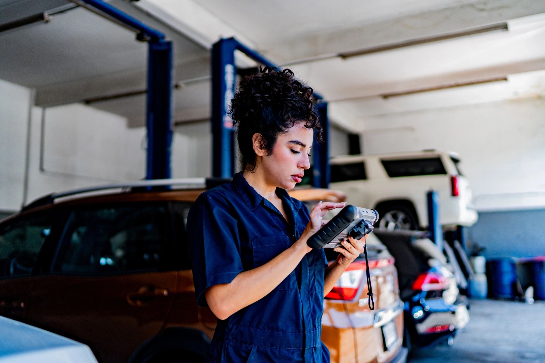 Technician using a diagnostic scanner in an auto repair shop