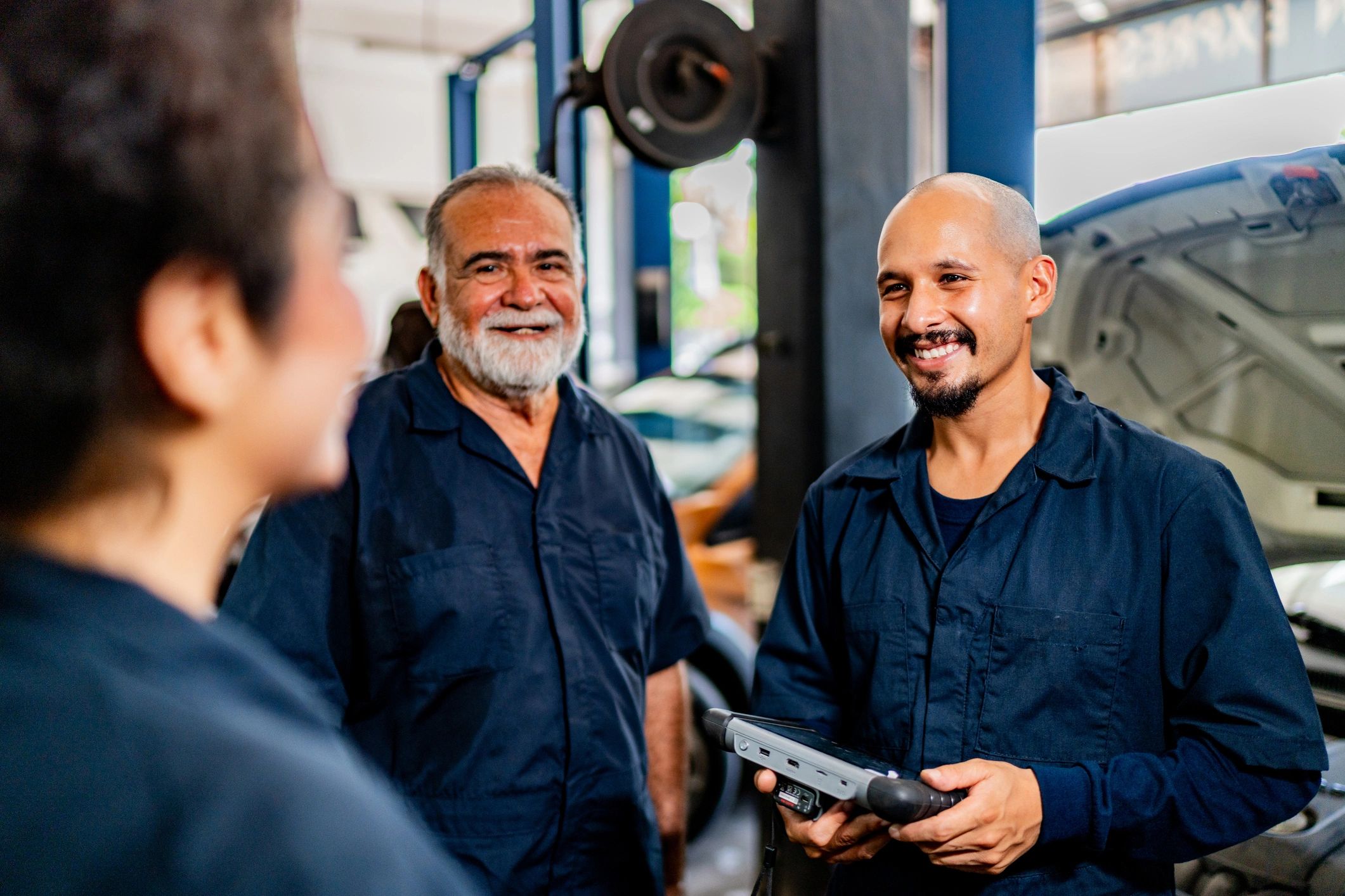 Customer speaking with mechanics at an auto repair shop