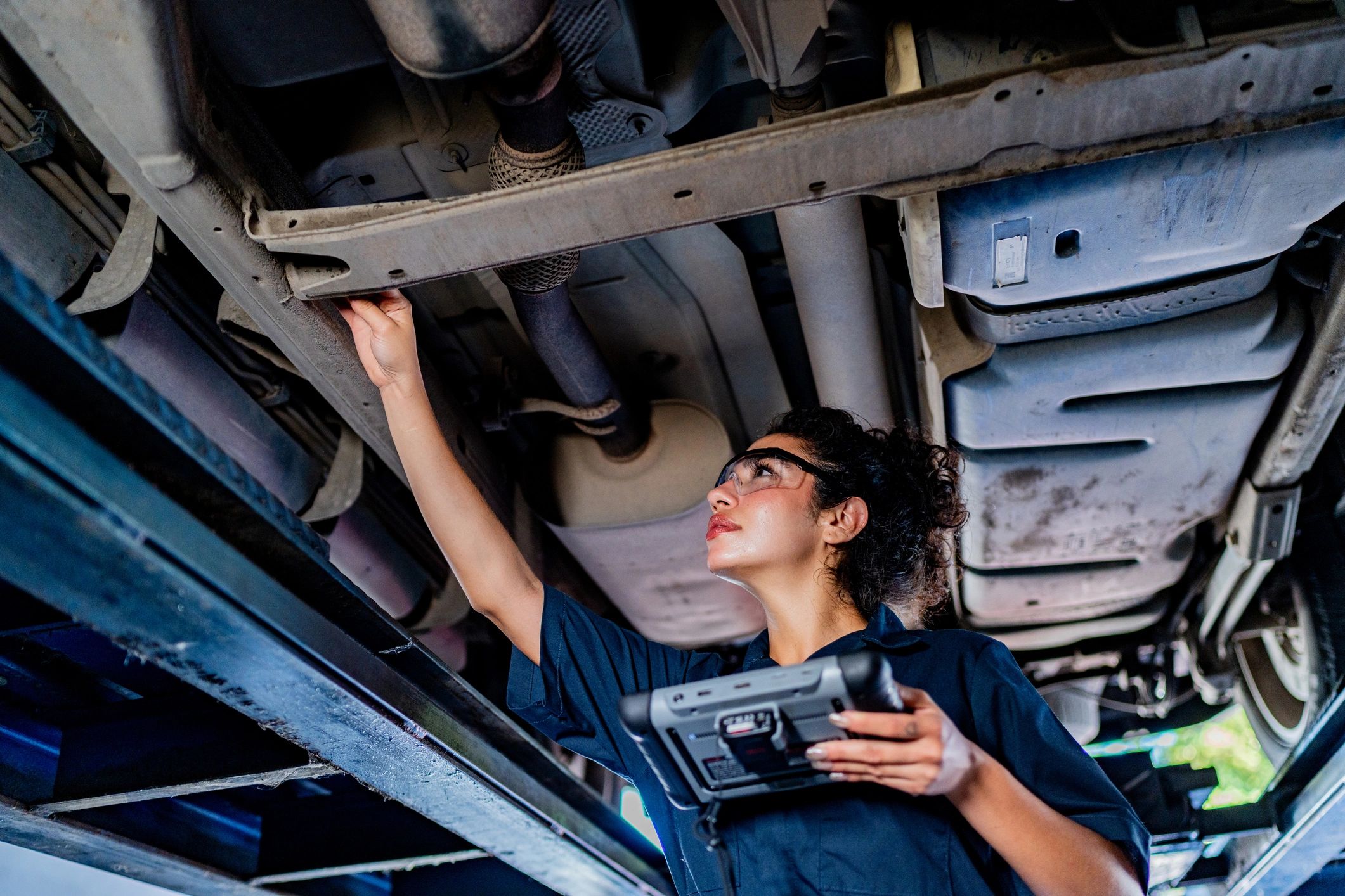 Technician inspecting a vehicle in the shop