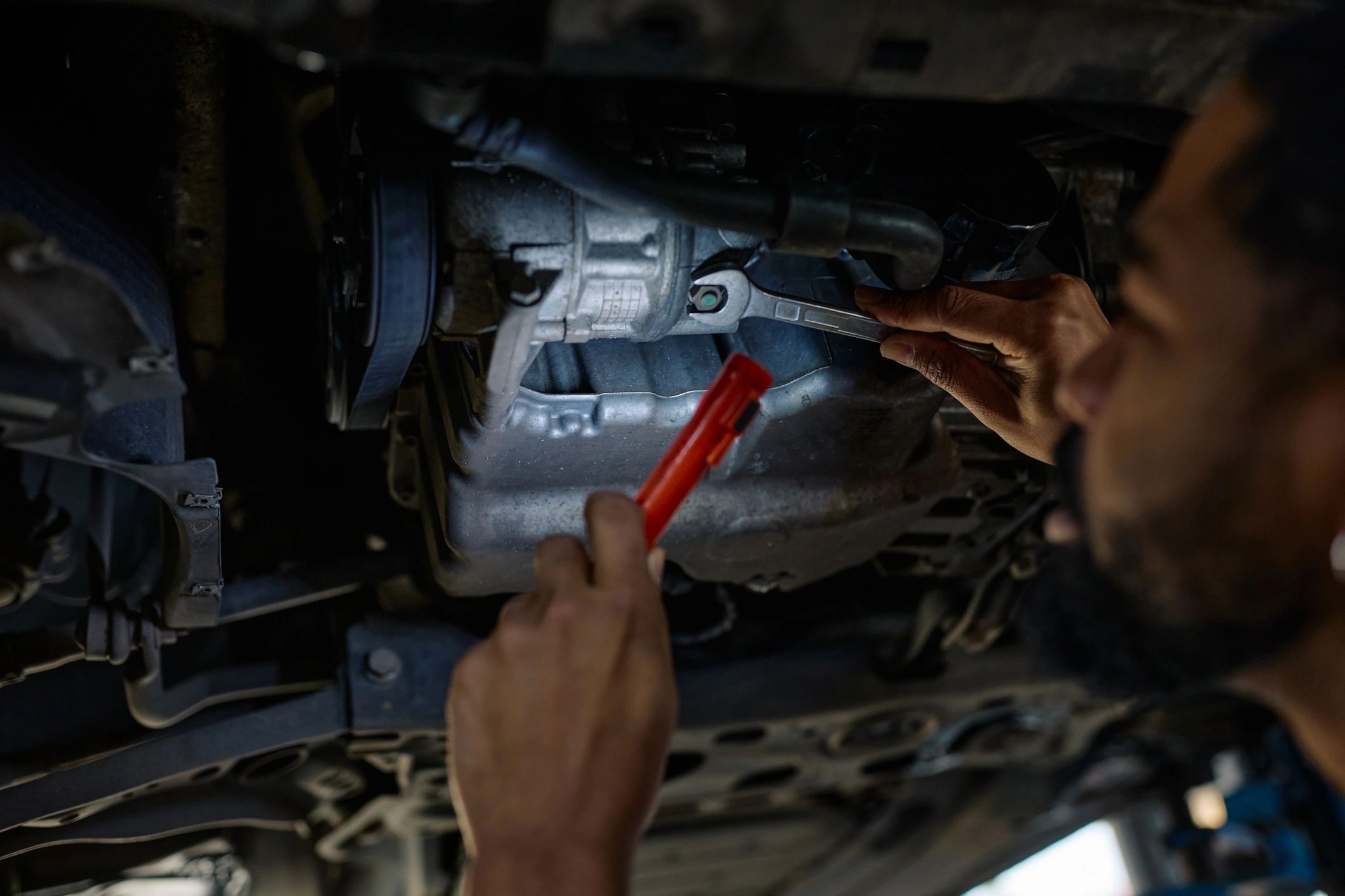 Mechanic inspecting a vehicle undercarriage on a lift